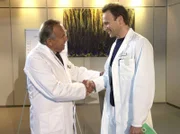 Prof. Simoni (Dieter Bellmann, links) gratuliert Dr. Martin Stein (Bernhard Bettermann). Er übernimmt interimsweise den Chefarztposten von Dr. Roland Heilmann, der sich mehr um seine an Brustkrebs erkrankte Frau kümmern möchte.