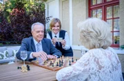 Werner (Dirk Galuba, l. mit Isabell Stern, 2.v.l.) setzt es zu, als ihn Wilma (Birgit Koch, r.) tatsächlich im Schach besiegt.