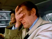 Auf dem Weg zum Flughafen wird es Dr. Erich Reimann (Alexander Kerst) am Steuer seines Autos schwindelig; auf dem Beifahrersitz seine Frau Edith (Thekla Carola Wied).