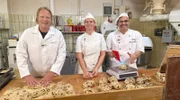 In der Stollenproduktion von Bäcker Jörg Liese (r) und seiner Mitarbeiterin Christiane Middel packt Björn Freitag tatkräftig mit an.