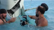 L-R: Joe Teti und Matt Graham im Wasser mit Teilen aus dem Flugzeug.