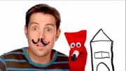 David zeigt der Puppe Red, wie man ein Bild auf eine Scheibe malt, und dann malt Red.