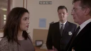 Die Frau hört sich die Aussage des Detektivs aufmerksam an.