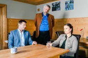 Die Kommissare Hansen (Igor Jefti?, l.) und Stadler (Dieter Fischer, M.) erfahren von Luise Schätzel (Cristina Andrione, r.) von einem Streit zwischen ihrem toten Ehemann und dem Koch Xaver Sänger.