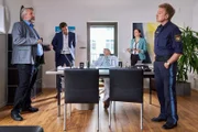 Polizeihauptmeister Mohr (Max Müller, r.) berichtet den Kommissaren Stadler (Dieter Fischer, l.) und Hansen (Igor Jeftic, 2.v.l.) sowie Pathologin Mai (Sina Wilke, 2.v.r.), dass an Türen und Fenstern keine Einbruchspuren zu finden sind. Hat das Opfer (Komparse, M.) also seinen Täter gekannt?