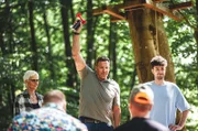 Ralf Moeller startet mit dem Luftdruckhorn die Uhr bei Motorsägen Masters. Sylvia Itzen und Tim Bengel sind gespannt auf die Kunstwerke der Teilnehmenden.