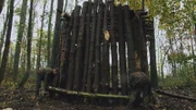 Zwei Menschen arbeiten mit Holz in einem Wald