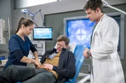Oskar Sonnenfeld (Paul Hofmann Wellenhof, M.) wird mit Bauchschmerzen bei Dr. Ben Ahlbeck (Philipp Danne, r.) und Sofia Galura (Olivia Papoli-Barawati, l.) vorstellig.