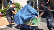 The fish maintenance guys rolling the tank from the truck into the building.