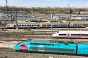 Zugbetrieb in den Gleisen vor dem Straßburger Hauptbahnhof. Im Vordergrund ein TGV Triebwagen der preisgünstigen Marke „ouigo" der französischen Staatsbahn SNCF. Dahinter ein ICE sowie ein Regionalzug „TER" der SNCF.