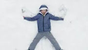 Olivia macht Schneeengel.