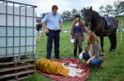 Jenny (Eva Bühnen, M.) hat auf der Wiese einen Toten gefunden. Zusammen mit Marie (Katharina Wackernagel, r.) und Heino (Sebastian Schwarz, l.) inspiziert sie Ragulans Leiche.