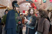 Der Gendarm (Oliver Korittke, li.) kauft Inga (Lea Müller) und Emil (Maximilian Ehrenreich) ein Schwefelhölzchen ab.
