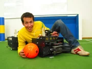 Willi Weitzel mit einem Fussballroboter. Heute erfährt er, dass ohne einen Computer und einem Programm kein Roboter funktioniert.