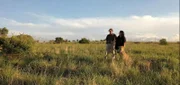 Elizke und Desmond Gouws mit Kiki, dem Geparden, bei einem gemeinsamen Spaziergang im Feld.