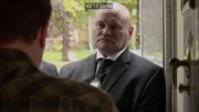 Die Polizisten stehen in der Tür und beobachten den Mann, der ihnen die Tür geöffnet hat.