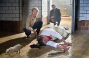 Kristina Katzer (Isabell Gerschke, l.) und Lukas Hundt (Oliver Franck, r.) entdecken Metzgermeister Lehmann tot auf dem Boden, getötet mit einem Bolzenschussgerät. Einziger Zeuge ist ein süßes Minischwein.