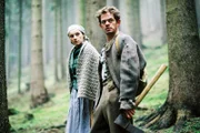 Hänsels und Gretels Vater (Henning Peker) und Stiefmutter (Claudia Geisler) blicken in die Richtung des Waldes, in der sie die Kinder ausgesetzt haben.