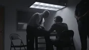 A detective interrogates a man.