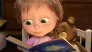Mascha liest dem Teddy etwas aus dem Märchenbuch vor.