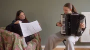 Jojo hört Alma das erste Mal Akkordeon spielen.