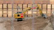 Ein Bagger gräbt auf einer Baustelle.