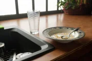 Halbleerer Teller mit Cornflakes und ein leeres Glas Milch