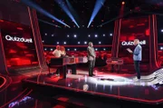 Moderator Jörg Pilawa (r.) mit den Kandidat:innen des Teams "Schlager": Schlagersänger Matthias Reim (l.) mit Ehefrau Christin Stark (2.v.l.), Schlagersängerin. Sowie dem Quizexperten Eckard Freise (M.).