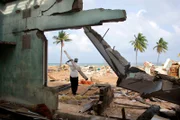 Ein Überlebender räumt ein Stück Schutt aus einem zerstörten Gebäude, nachdem der Tsunami das Gebiet in Sri Lanka verwüstet hat.