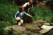 Anne (Laura Petela, li.) zeigt Dick (Paul Child, re.) die Steinplatte, die sie entdeckt hat und die von zwei seltsamen Fremden bereits verzweifelt gesucht wurde.