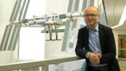 Karsten Schwanke vor einem Modell der Raumstation ISS beim Deutschen Zentrum für Luft- und Raumfahrt in Köln.