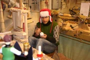 Willi bemalt einen Holzengel in einer Drechslerei. Er ist diesmal zur Weihnachtszeit im Erzgebirge unterwegs.