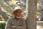Morgan Freeman leans against a tree at a park in Glendale, California.
