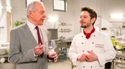Werner (Dirk Galuba, l.) hält sich mit Lob zurück, als er Luis‘ (Michael Baral, r.) Dessert probiert.