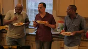 The doctors standing and eating in the kitchen at the crawfish boil dinner.