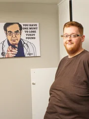 Justin poses with Dr Now wall art.