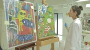 Restauratorin Charlotte begutachtet den Stand ihrer Kopie von Karel Appel im Vergleich zum Original.
