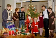 Als Weihnachtsmänner verkleidet organisieren der kleine Jonas Heilmann und die kleine Lisa Schroth die Bescherung für die Großfamilie. Von rechts: Christina Buchmann (Iris Böhm), Dr. Martin Stein (Bernhard Bettermann), Marie Stein (Henriette Zimmeck), Lisa Schroth (Ella Zirzow), Jonas Heilmann (Anthony Petrifke), Dr. Roland Heilmann (Thomas Rühmann), Pia Heilmann (Hendrikje Fitz) und Jakob Heilmann (Karsten Kühn).