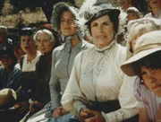 (v.l.n.r.) Grace Snider (Bonnie Bartlett), Margaret Mumford (June Dayton), Caroline Ingalls (Karen Grassle), Mrs. Oleson (Katherine MacGregor), Nellie (Alison Arngrim) und ihr Bruder Willie (Jonathan Gilbert) verfolgen gespannt das Baseballspiel zwischen Grove und Sleepy Eye.
