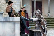 Allerleirauh (Henriette Confurius) zieht Jakob (André Kaczmarczyk) die Stiefel aus, Rasmus (Adrian Topol) sieht zu.