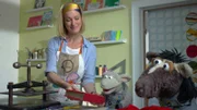 Julia hilft Wolle und Pferd dabei, das geliehene Buch zu reparieren.