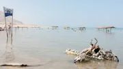 Strand von Ein Gedi am Totem Meer, Israel (428m. unter dem Meeresspiegel). Im Vordergrund alte Fahrräder von Salz bedeckt.