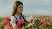 Ein Mädchen in einem von Blumen umgebenen Feld.
