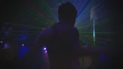 Miami, Florida, USA: A 'clubber' dances in a nightclub while a light show goes on behind him.