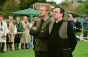 Reverend Anthony Gant (Richard McCabe) muss sich zu Pferd gegen eine Schar Frauen behaupten - so will es die Tradition dieses Dorffestes. Roland Marwood (Joseph Kennedy) wird ihm die Daumen drücken.