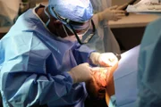 Doctor cutting in to Reginald's neck.