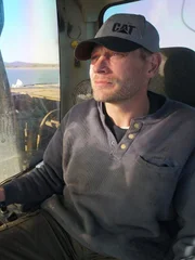 Shawn Pomrenke sits comfortably in the cabin of his excavator as he patiently looks for gold on the ocean floor.