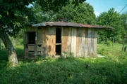 Wooden house in a field.