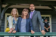 Melody Henderson (Natasha Little, l.), ihre Freundin Serena Luthando (Esther Hall, M.) und deren Ehemann Elliot Luthando (Joe Dixon, r.) verfolgen das Geschehen auf dem Cricket-Platz. Noch wissen sie nicht, dass Melody inzwischen Witwe ist. 'Last Man Out'