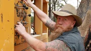 Rod Manning (die "Buschmänner") bedient eine Maschine, lachend, Grawin NSW.
